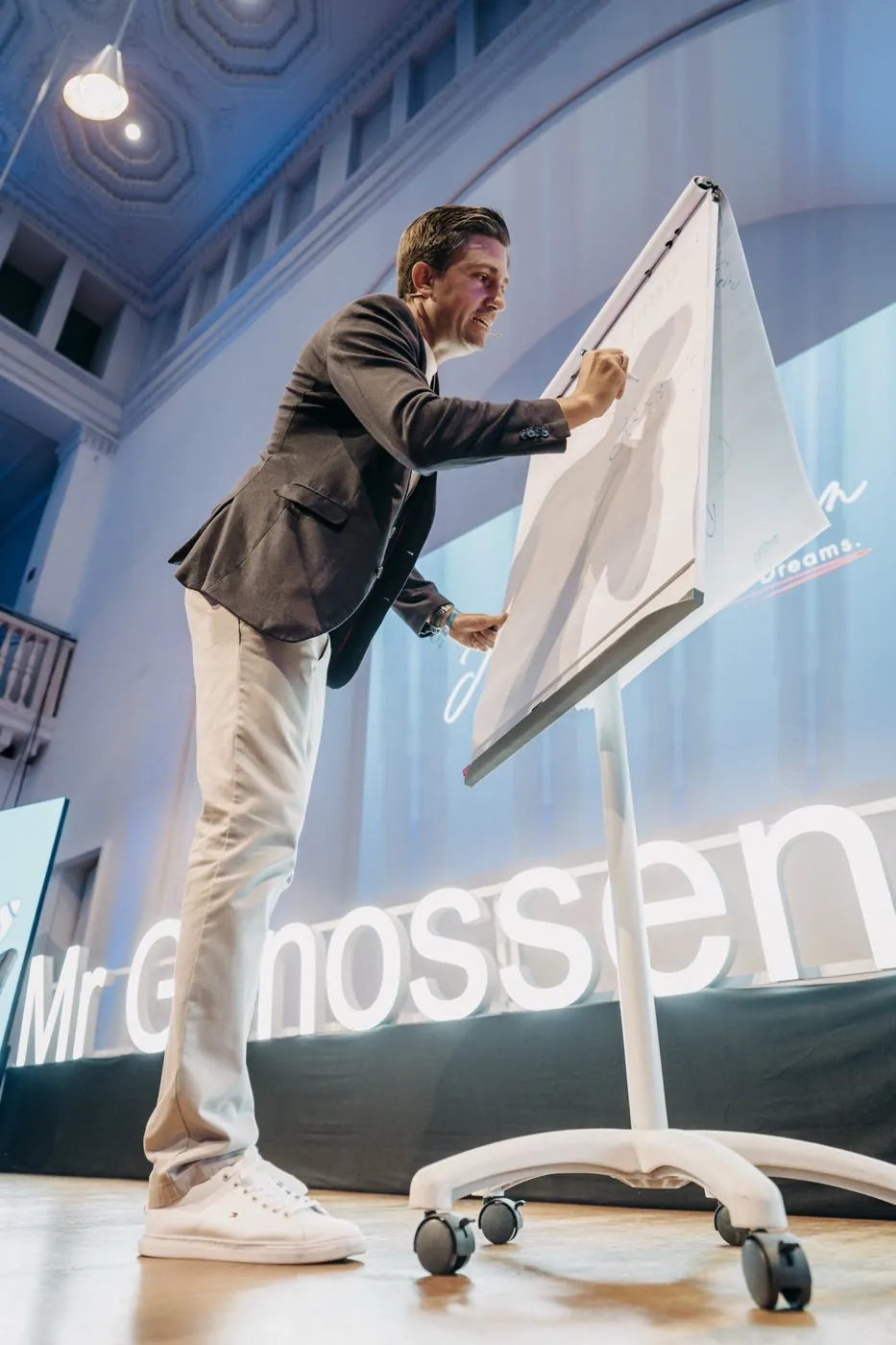 Jay Feldmann schreibt auf der Bühne am Flipchart